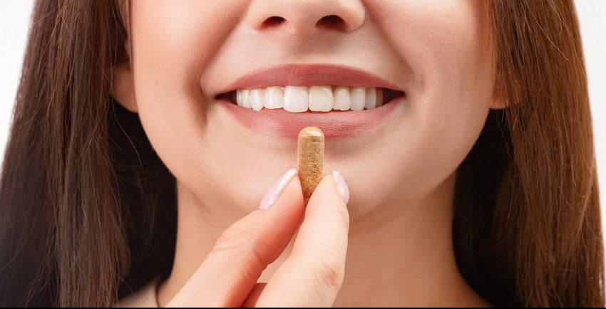 Lady smiling taking a capsule