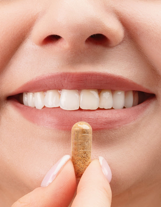 Woman smiling about to take a capsule